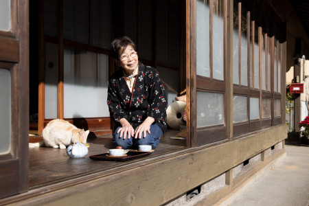 The owner of Nukumori enjoys tea and her cat's company.