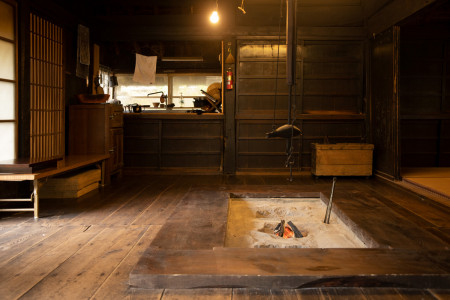 A traditional room with a hearth in the center.