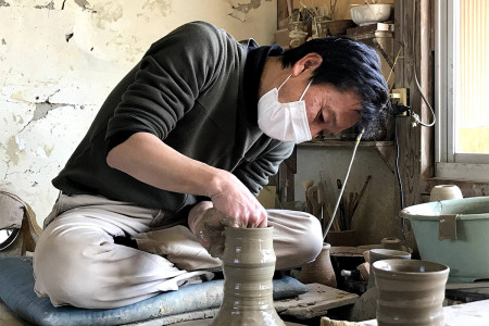 A skilled crafter shapes pottery at the wheel.